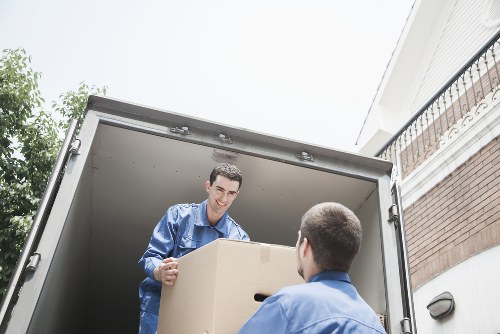 Removal workers carrying furniture through a flat building in Brent